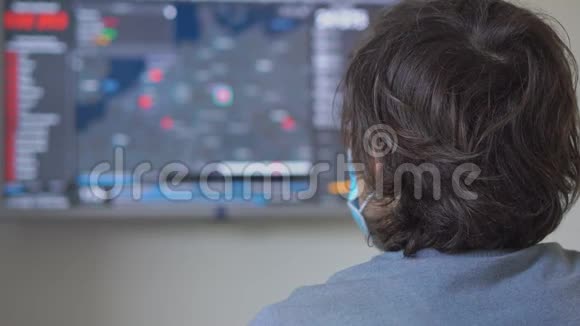 一个戴着医用口罩的年轻人看着屏幕屏幕上有多少人感染了covid19视频的预览图