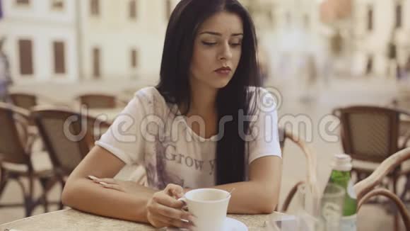 一位年轻悲伤的女士在高清电视的餐厅喝咖啡结束愉快视频的预览图
