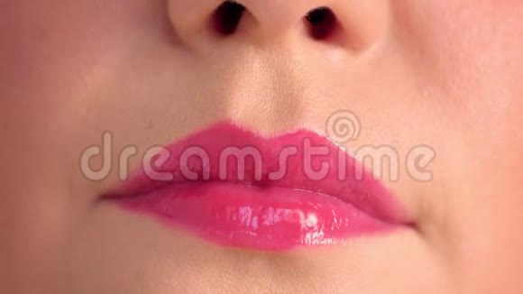 女性嘴的特写与浆果唇彩微笑视频的预览图