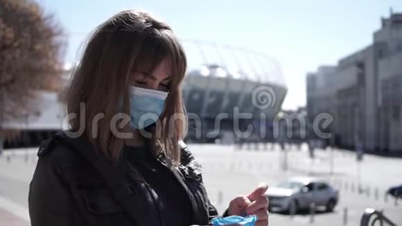 戴口罩的年轻女性在冠状病毒流行期间在户外戴上乳胶手套视频的预览图