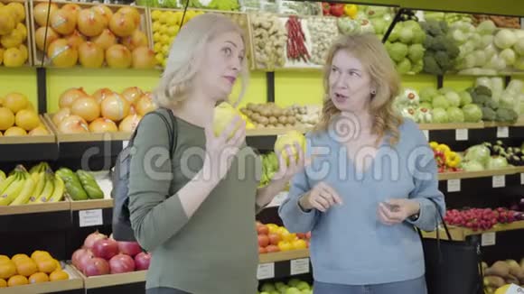 成熟的白人女性在杂货店里有感情地交谈和手势积极的家庭主妇在超市闲聊视频的预览图
