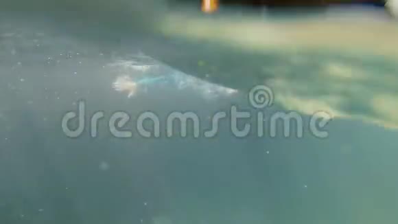 女孩在水里和水下游泳挥动双手快乐岩石上的峡谷视频的预览图