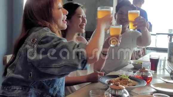 快乐的年轻团队在餐厅用餐和喝啤酒视频的预览图