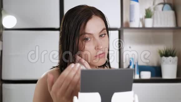 女孩把泡沫放在湿发上浴室里年轻漂亮的女人照镜子用泡沫来做发型视频的预览图