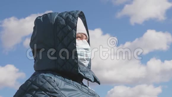 大流行冠状病毒一位戴着医用口罩和头巾的老年妇女女人在街上戴防护面具视频的预览图