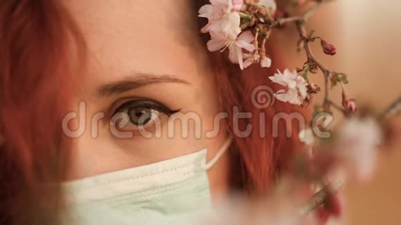 担心红头发的女人戴着手术面具看着你头上的樱花视频的预览图