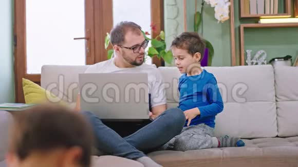 爸爸和他的两个孩子在家玩得很开心他们在一起聊天小儿子穿着蜘蛛侠套装视频的预览图