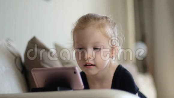 远程学习儿童在线教育在智能手机前在家学习的小女孩儿童观看视频的预览图