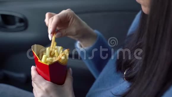 女孩在车里吃炸薯条视频的预览图