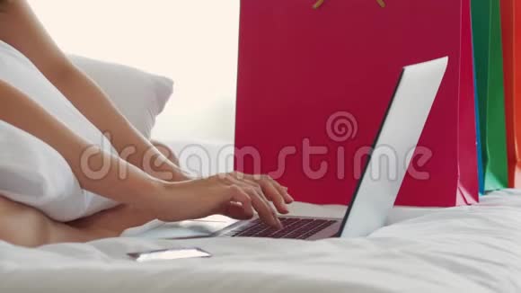 使用电脑笔记本电脑使用社交媒体和网上购物信用卡的年轻女性亲密接触视频的预览图