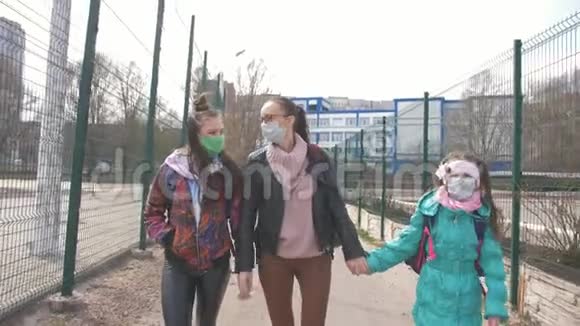 母亲带着两个戴防病毒口罩的女儿在街上视频的预览图