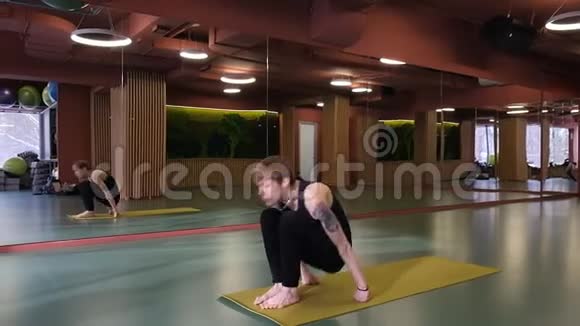 瑜伽教练开始上课一个有纹身的小可爱坐在垫子上的莲花位置上课视频的预览图