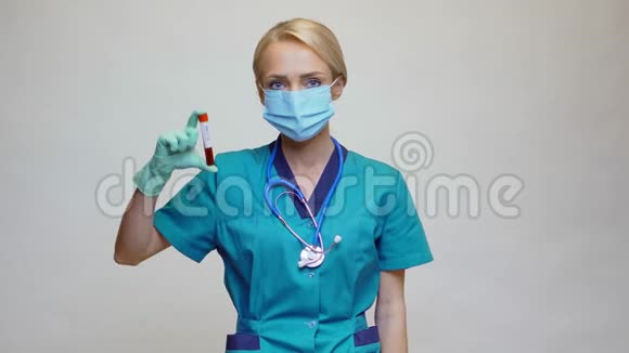 医生护士戴防护面罩和手套的妇女持有COVID19血液测试视频的预览图