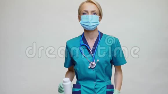 医生护士戴防护面罩的妇女药丸或维生素罐视频的预览图
