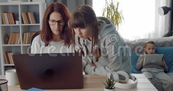 成熟的女人帮助她十几岁的女儿做家庭作业视频的预览图