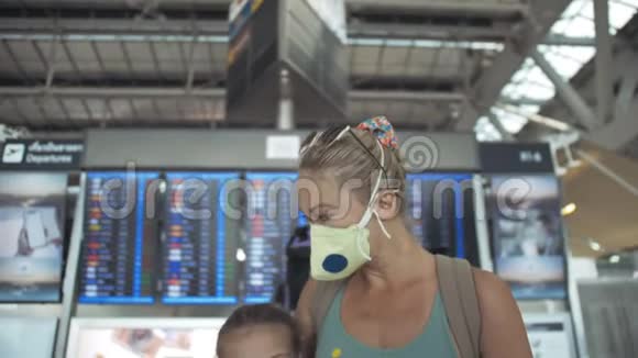 女子和儿童婴儿旅游白种人在机场戴防护医疗面具隔离隔离的家庭视频的预览图