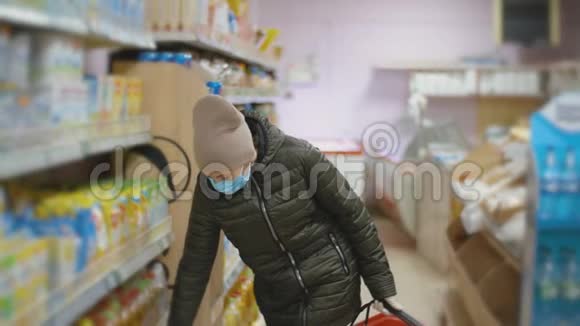 戴着医用口罩的女人在超市里一排排走来走去视频的预览图