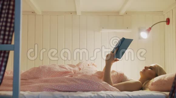 晚上穿着内衣的女人读完了书关了灯睡在舒适的宿舍里视频的预览图