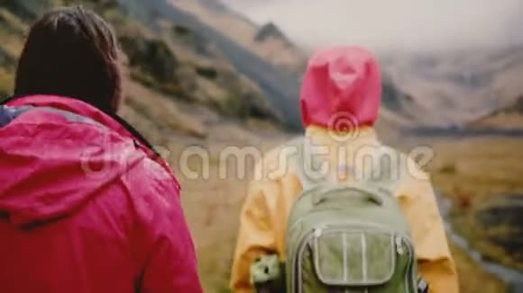 两个年轻女子背着背包在山上行走在雾蒙蒙的早晨游客们一起徒步旅行视频的预览图