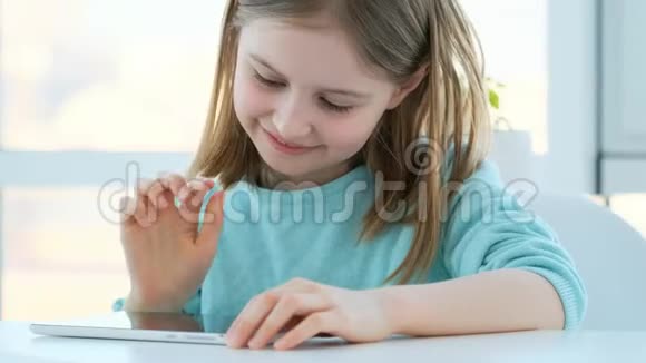 漂亮的小女孩用平板电脑视频的预览图