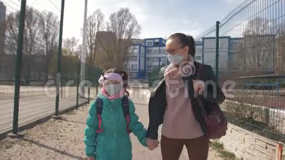 妈妈牵着女儿手他们一起戴着防护面具走在街上视频的预览图