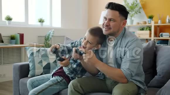 男人和男孩在家玩电子游戏的慢动作视频的预览图
