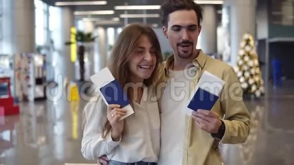 兴奋的白种人夫妇去度假在机场持护照登机牌办理登机手续视频的预览图