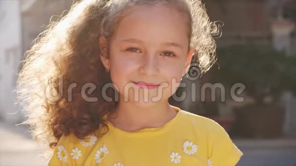 有趣的小女孩微笑着看着街上的摄像机一个可爱的孩子在街上玩耍画着画视频的预览图