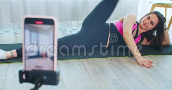 由一名年轻女子在手机上录制的在线瑜伽课程检疫4k视频的预览图