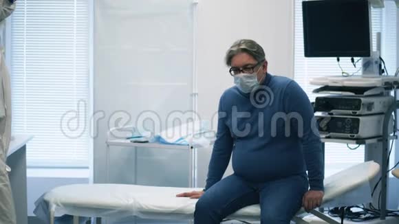 穿防毒服的医生正在测量一位老人的体温医院里生病的冠状病毒病人covid19概念视频的预览图