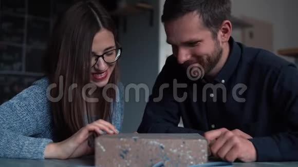 兴奋的白种人年轻浪漫夫妇打开惊喜假日礼品盒与神秘的灯光内慢动作视频的预览图
