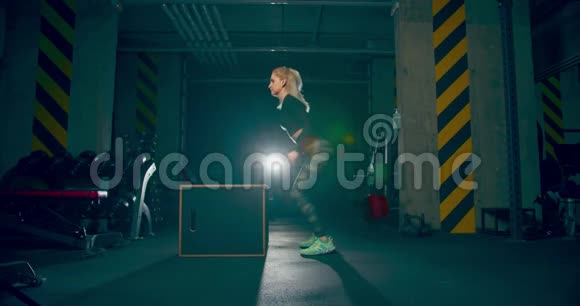 运动员女孩垂直在体育馆的立方体上跳跃没有摄像机的动作视频的预览图