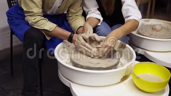这对肮脏夫妇双手合拢恋爱中的浪漫夫妇一起工作在陶工轮和雕刻泥锅妇女视频的预览图