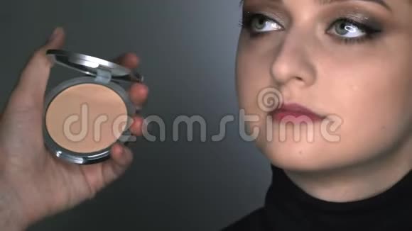 化妆师为美容工作室的年轻女性制作专业化妆化妆师用刷子涂闪光视频的预览图