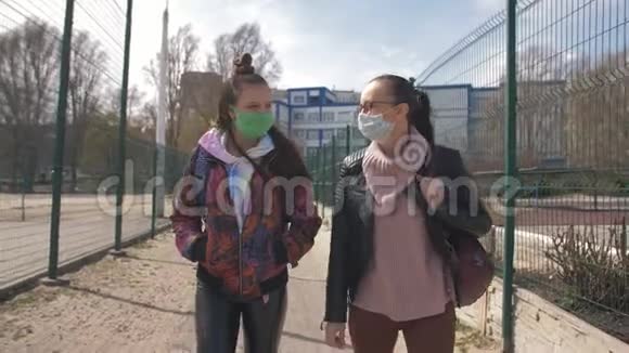 母亲和女儿是一个戴着防护面具走在街上的青少年视频的预览图