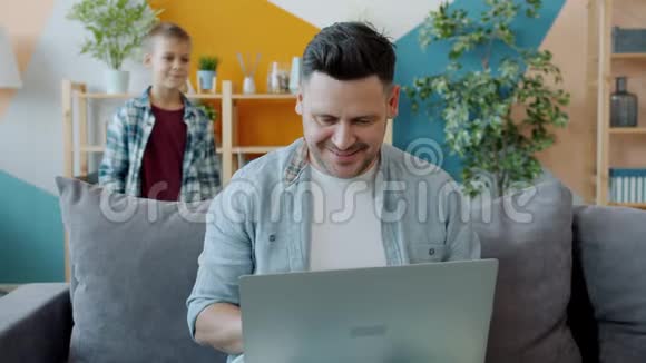 爸爸用手提电脑然后和一个可爱的孩子对着电脑屏幕说话视频的预览图