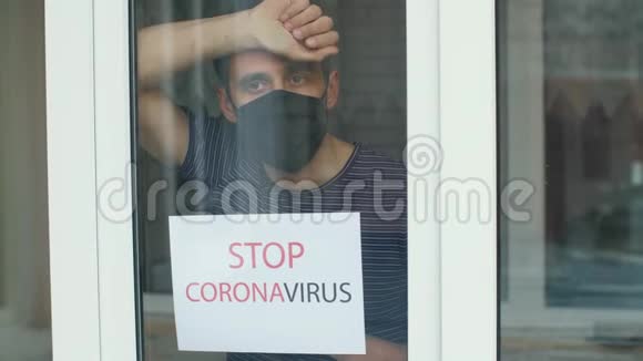 戴着防护面具的人在窗外阻止冠状病毒视频的预览图