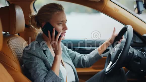 从侧面看女商人在车上打电话女人靠在方向盘上视频的预览图