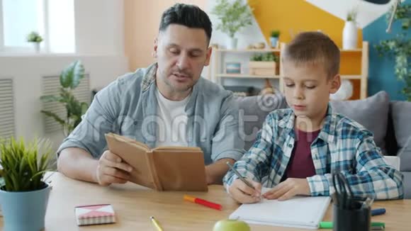 当孩子在公寓的办公桌上画画的时候爱看爸爸在给孩子看书视频的预览图