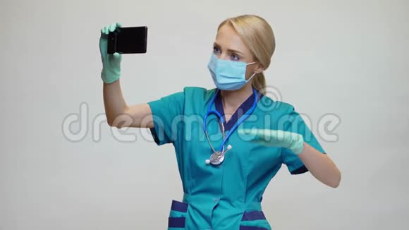医生护士女士戴防护面罩和乳胶手套打电话视频电话视频的预览图