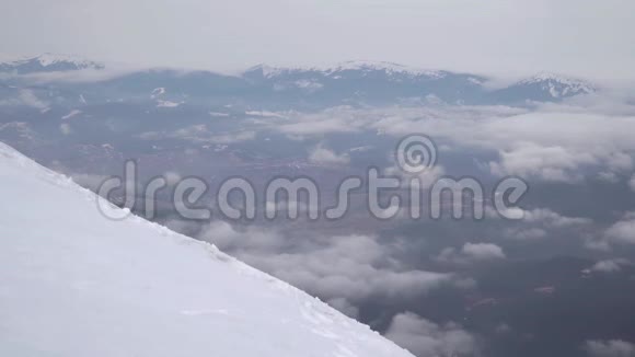 一个旅行者爬上雪山的山坡视频的预览图