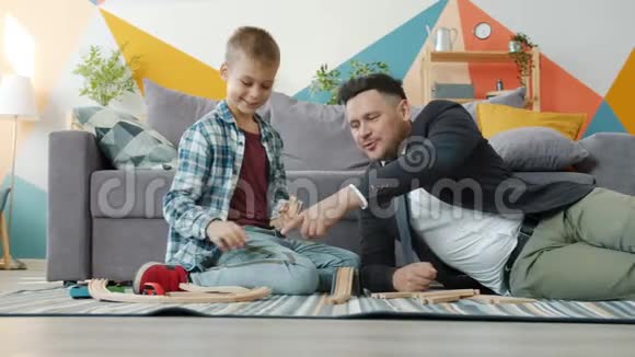 爸爸商人玩可爱的小儿子拿着玩具放松休闲时间视频的预览图