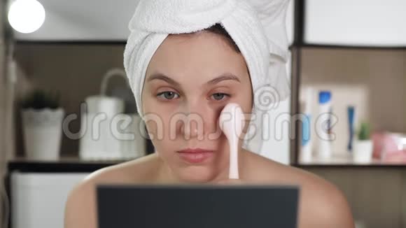 女孩用按摩器做下眼睑浴室里漂亮的女人照镜子用眼睛附近的皮肤按摩视频的预览图
