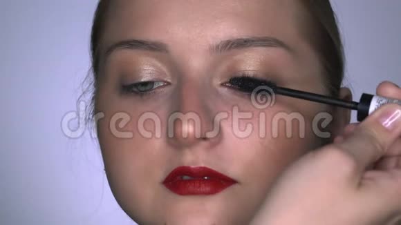 化妆师为美容工作室的年轻女性制作专业化妆化妆艺术家画睫毛膏视频的预览图