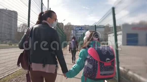 流行病情况母女俩戴着防护面具一起走向学校视频的预览图