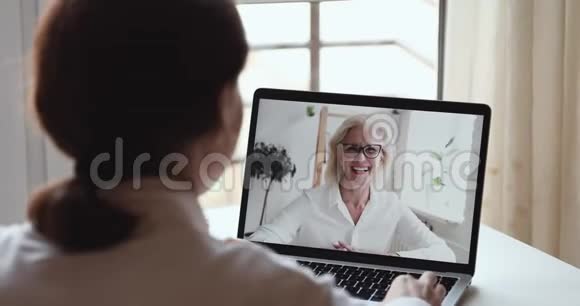 友好的快乐的年长的女商人视频称年轻的女儿为网络摄像头视频的预览图