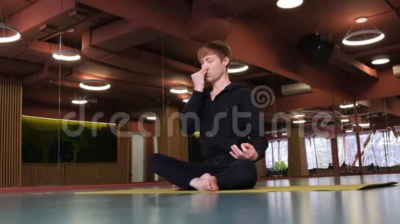 一个年轻英俊的高加索男人正在做瑜伽他在练习呼吸视频的预览图