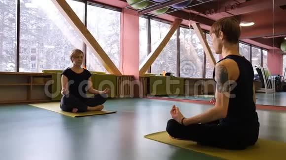 一男一女做瑜伽他们坐在莲花的位置对面经常呼吸实践视频的预览图