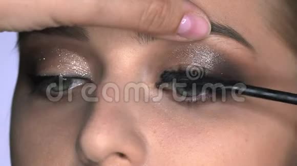 化妆师在美容工作室为年轻女性做专业化妆化妆师用睫毛膏视频的预览图