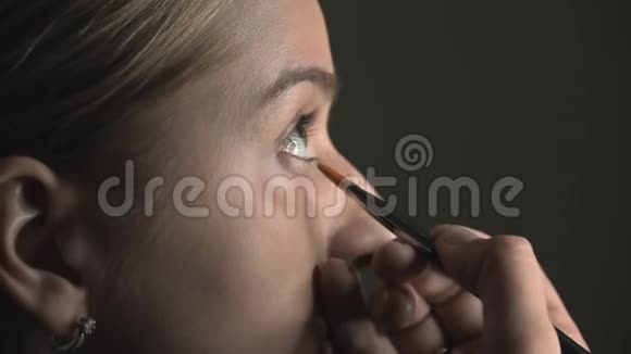 化妆师为美容工作室年轻女性做专业化妆的侧视化妆师申请视频的预览图
